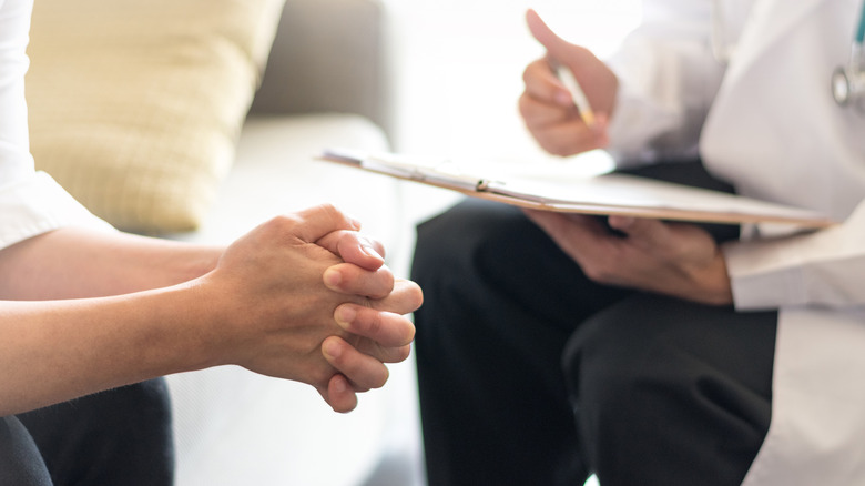 Counselling session clipboard clenched hands