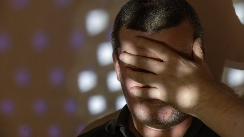 adult man covering his face