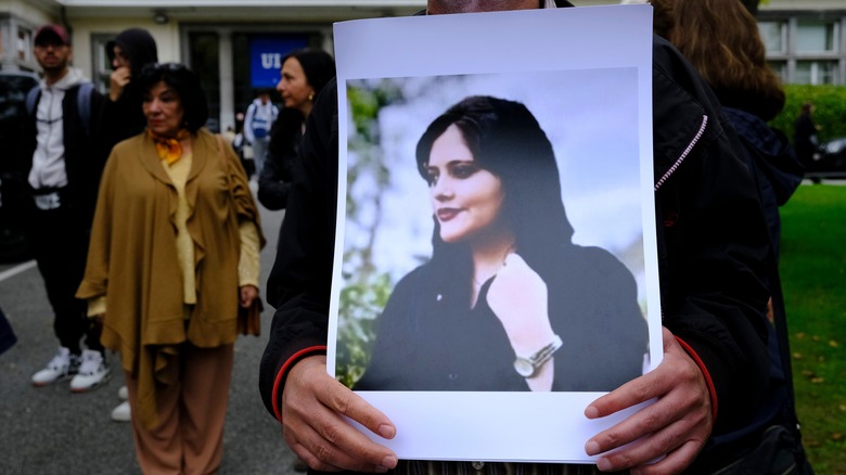 Protester with picture of Mahsa Amini 