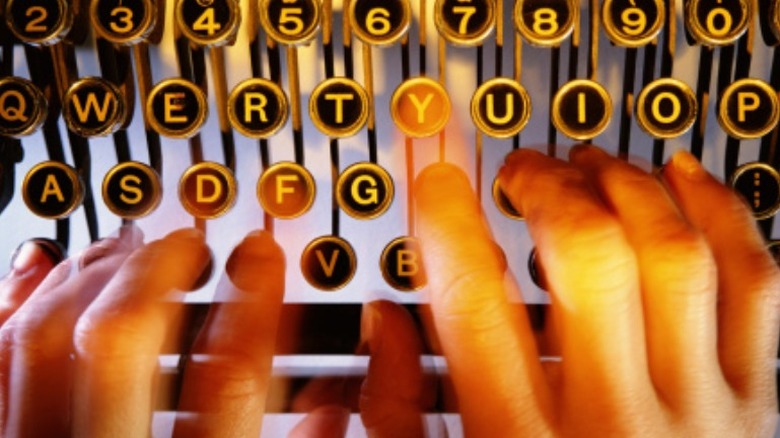 fingers striking typewriter keys