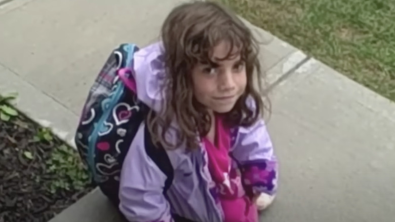 Home movie still of Natalia Grace as child wearing backpack