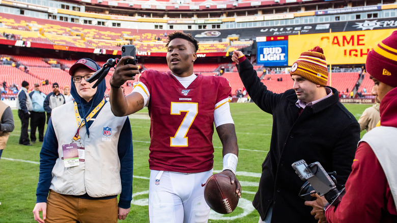 Dwayne Haskins with others holding phone