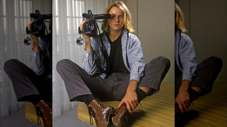 River Phoenix holding a camera