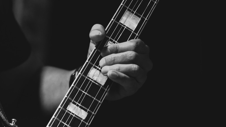 Holding a guitar by the neck