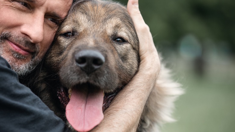 Man hugging young dog