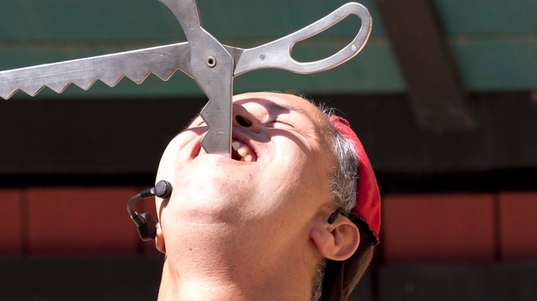 Performer swallowing large scissors