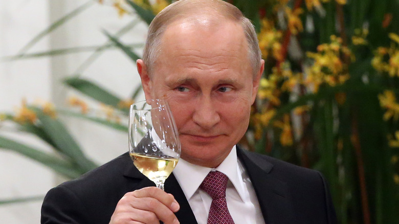 Vladimir Putin toasting with a glass