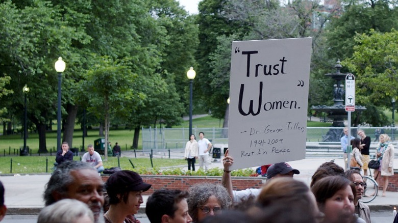 Protester with sign reading "Trust women"