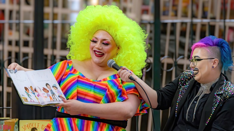 Drag king and queen reading storybook smiling