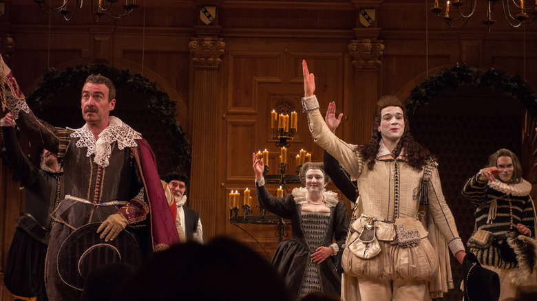 Actors performing Shakespeare arms raised