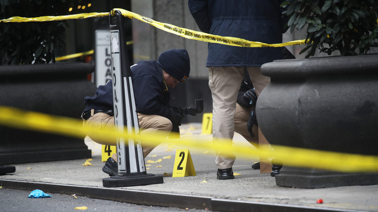 Police place bullet casing markers outside of the Hilton Hotel in Manhattan