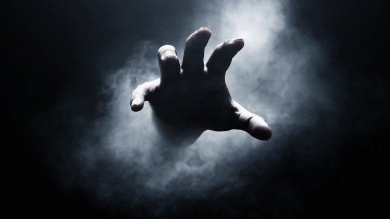 Hand reaching from gray background