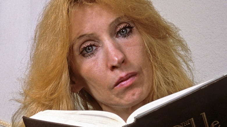 debbie nelson reading a large bible while looking at camera