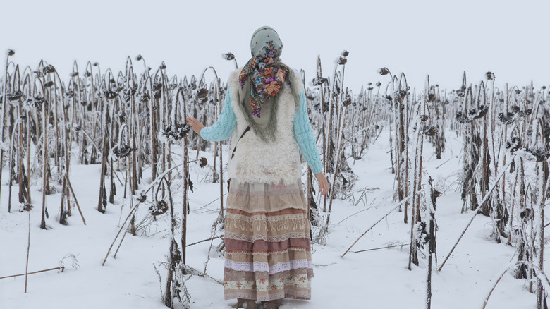 Peasant in frozen crop field