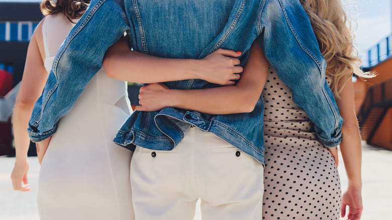 Three people with arms around each other