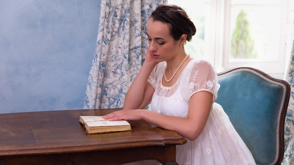 Young women reading a novel in 19th century garb 