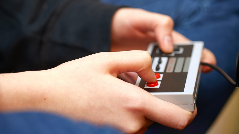 Hands playing a classic Nintendo controller