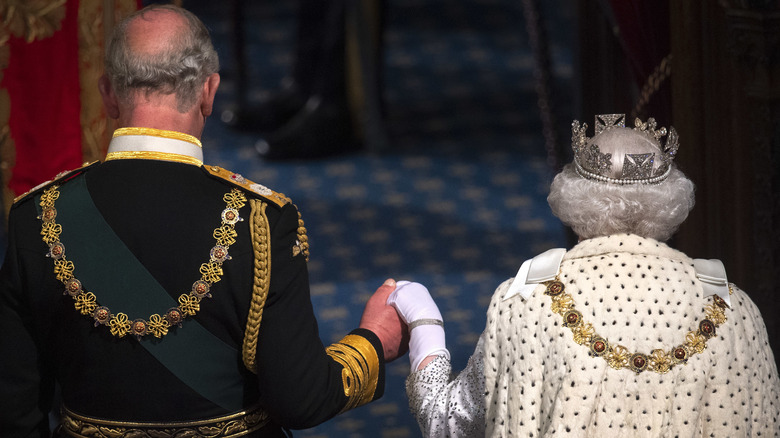 King Charles III holding Elizabeth's hand