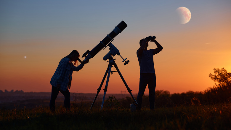 people observing sky through telescope and binoculars