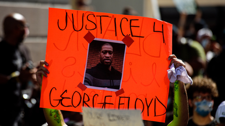 person holding George Floyd poster