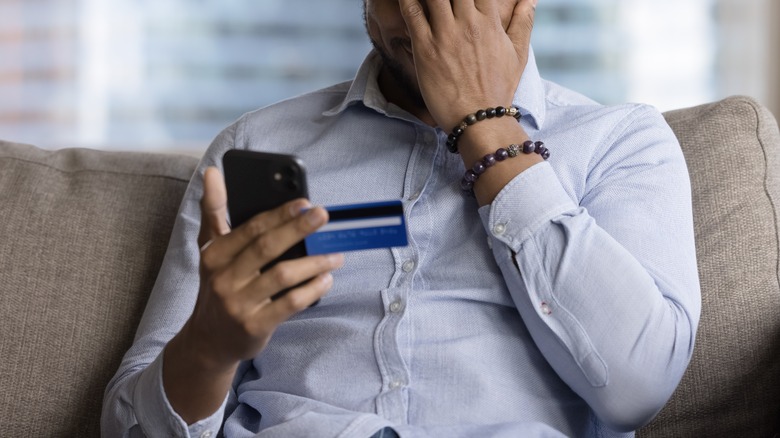 Guy holding phone after losing money