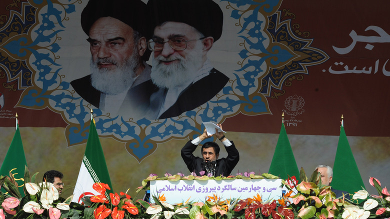 Khomeini and Khamenei's portraits loom over Mahmoud Ahmadinejad