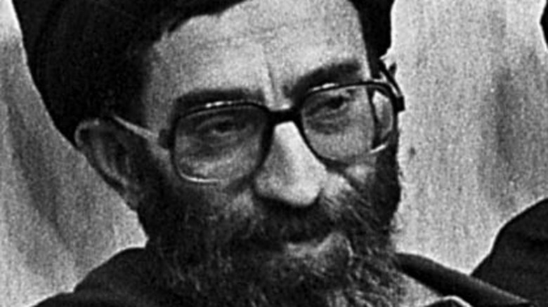 A young Ali Khamenei glances sideways during a chat