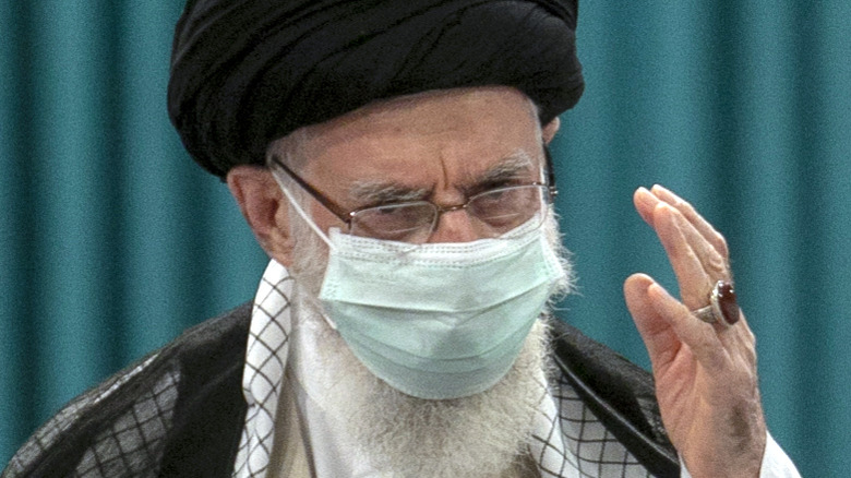 A masked Ali Khamenei leads prayers