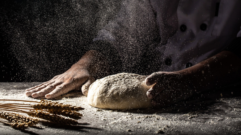 Baker working flour into dough