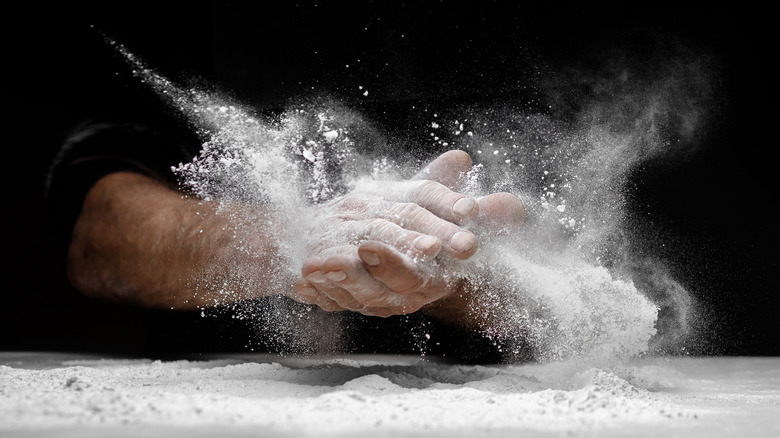 Man's hands clapping flour