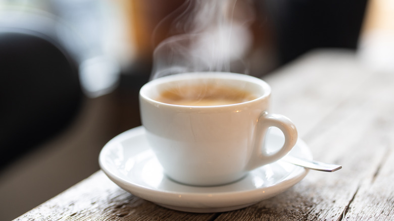 A steaming cup of coffee on a saucer