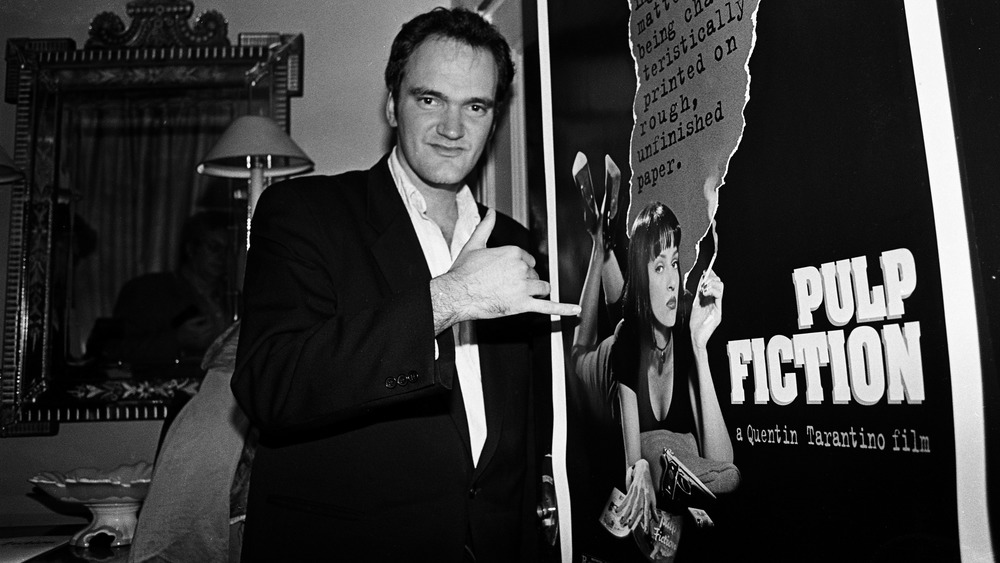 Quentin Tarantino next to Pulp Fiction poster