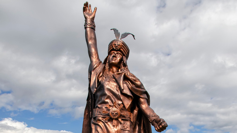 A statue of Atahualpa with his hand in the air