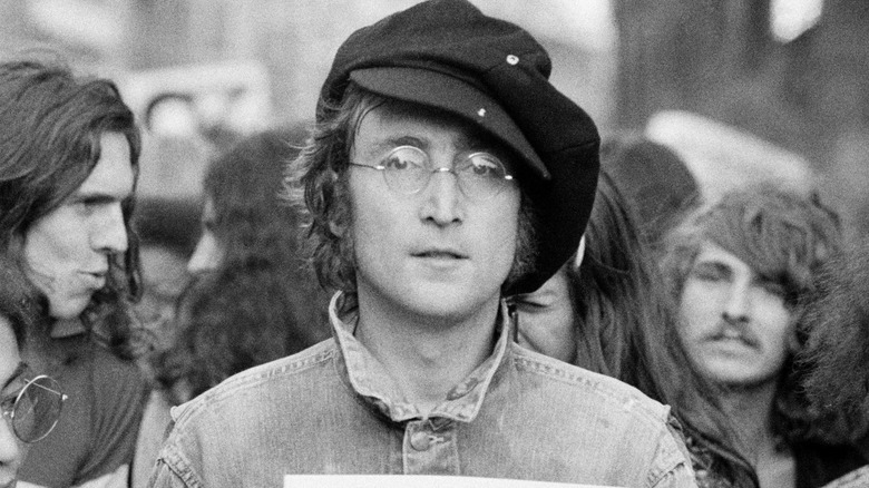 John Lennon holding sign