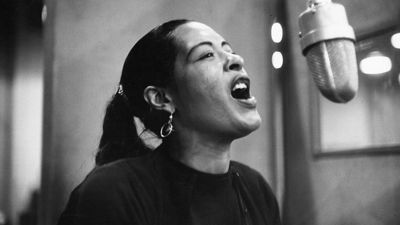 Billie Holiday singing at microphone