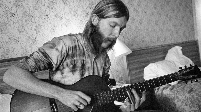 Duane Allman playing acoustic guitar