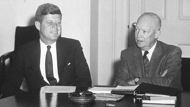 JFK and Ike smiling suits at table