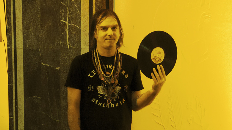 Anton Newcombe holding a vinyl LP