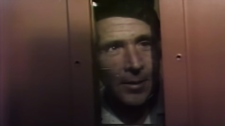 henry lee lucas looking out the window in a prison cell door