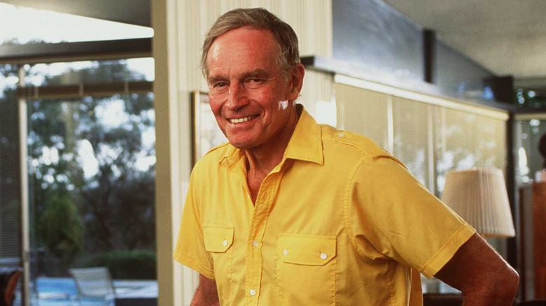 Charlton Heston smiling in yellow shirt