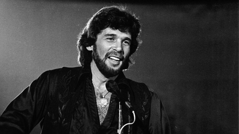 Eddie Rabbitt singing into a microphone