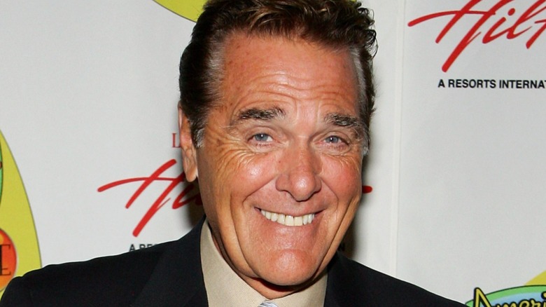 Chuck Woolery smiling with raised eyebrows