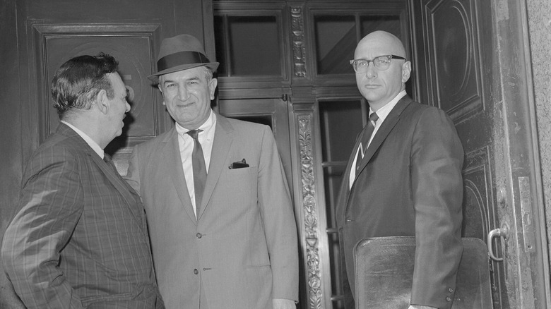 Joseph Bonanno, his lawyer, and a reporter talking in a courthouse