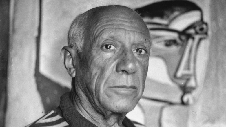 Pablo Picasso with a painting
