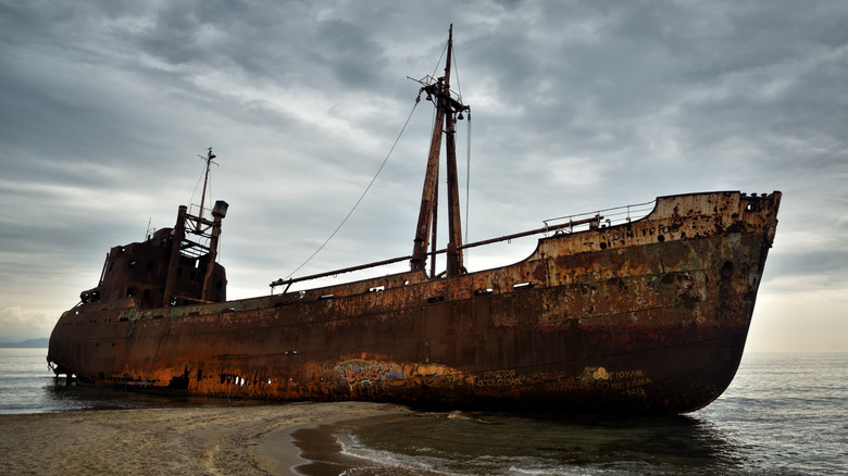 rusty, abandoned ship under cloudy sky