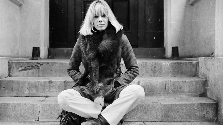 Anita Pallenberg sitting on steps outside