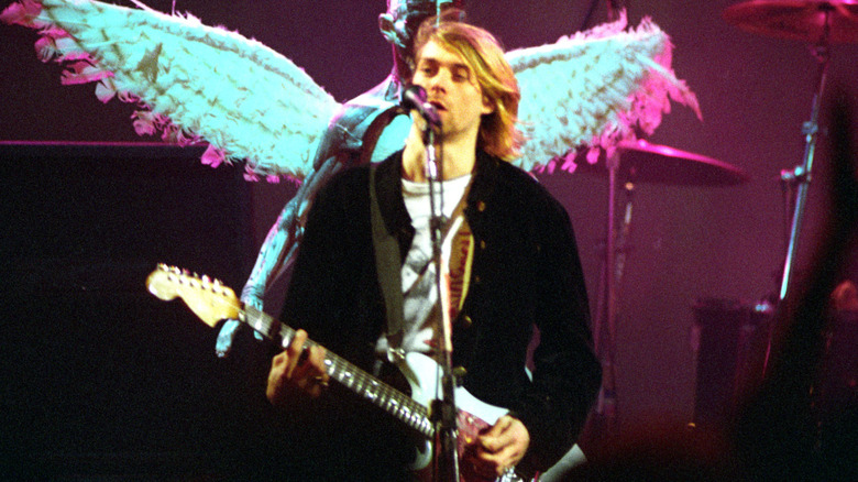 Kurt Cobain playing guitar and singing onstage