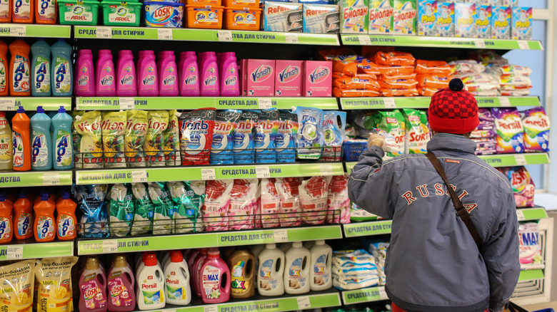 Man in front of shelves of cleaning supplies in store