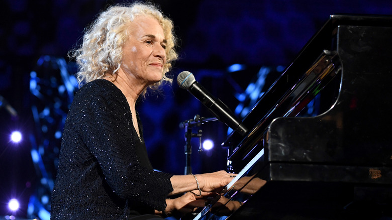 Carole King playing piano onstage