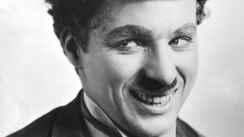 Performer Charlie Chaplin grins in character